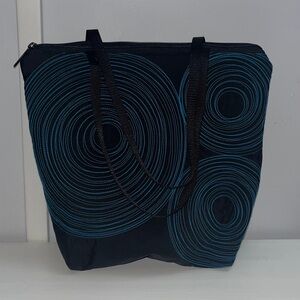 Black and Blue Embroidered Tenacious Tote Bag with signature blue spirals